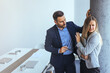 © Dragana Gordic - Man in Office Interacting Uncomfortably with Woman Holding Laptop