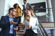 © Dragana Gordic - Professional Colleagues Discussing While Walking Down Office Stairs
