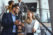 © Dragana Gordic - Professional Business Team Interacting and Smiling While Walking Down the Office Stairs