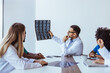 © Dragana Gordic - Medical Professionals Reviewing Brain Scans During a Conference in Modern Office