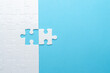 © AndS - Concept for problem-solving, teamwork, solutions, or missing connections. White jigsaw puzzle on a vibrant blue background with one missing piece. Minimalist composition with copy space.