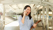 © chinnarach - close up young beautiful asian businesswoman talk on phone with with excited and happiness feeling after complete and get a new job position in city for new career path concept