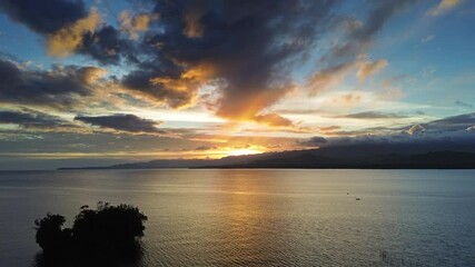 Wall Mural - aerial view of stunning sunset over calm sea waters with vibrant colors illuminating the sky, 4k