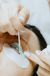 © Nataliya - Girl cosmetologist laminates and paints woman eyelashes