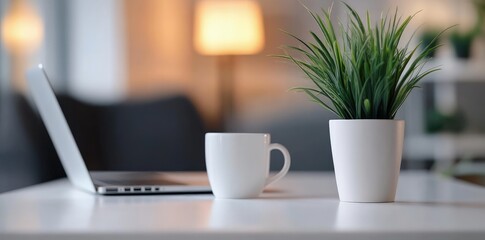 Aufkleber - Minimalist home office setup with a laptop, coffee mug, and potted plant on a white desk against a blurred background, ideal for remote work, productivity, or workspace visuals