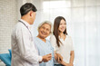 © Wanwajee - Senior elderly woman delighted after receiving treatment at clinic. Physician doctor and young lady standing beside old patient in hospital room.