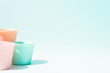 Poster - minimalistic arrangement of pastel-colored plastic containers on white background with large copy sp
