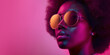 © J S - Young black afro woman wearing vintage disco sunglasses, copy space on pink magenta background