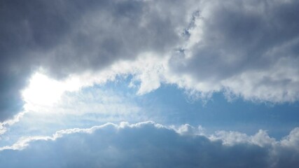 Poster - In a tranquil sky, vibrant clouds swirl gracefully while the sun pierces through, casting warm light across the vast blue above. The beauty of nature unfolds moment by moment.