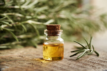 Wall Mural - A bottle of rosemary essential oil on a table