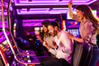 © Dragana Gordic - Friends Celebrating a Win at Slot Machines in a Vibrant Casino Setting