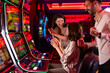 © Dragana Gordic - Group of Friends Celebrating at Slot Machines in a Vibrant Casino