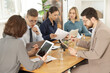 © New Africa - Coworkers working together at wooden table in office