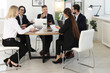 © New Africa - Coworkers working together at wooden table in office