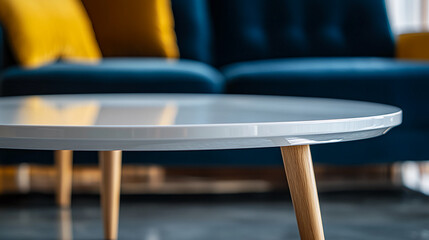 Aufkleber - Close-up of white round table top with light wood legs, blurred blue sofa background, showcasing modern furniture design, ideal for interior decor mockups