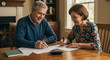 © Noor  - A retired couple carefully reviewing their financial documents together at home, enjoying a peaceful moment of planning for the future with warm, soft indoor lighting.