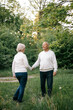 © Максим Галінский - 28.09.24 Vinnitsa, Ukraine: a nice couple of grandparents who look good and pose for a photo in light clothes in front of a park