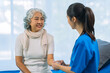 © ArLawKa - Asian female doctor consulting elderly patient at home, explaining diagnosis and treatment plan, providing health care to elderly woman, medical health concept