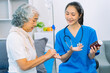 © ArLawKa - Asian female doctor consulting elderly patient at home, explaining diagnosis and treatment plan, providing health care to elderly woman, medical health concept
