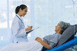 © ArLawKa - Asian female doctor consulting elderly patient at home, explaining diagnosis and treatment plan, providing health care to elderly woman, medical health concept