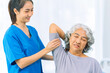 © ArLawKa - Elderly woman receives medical services from home care nurse while performing muscle strengthening exercises.