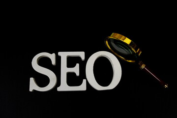 Aufkleber - Seo words (Search Engine Optimization) letters with magnifying glass on black background