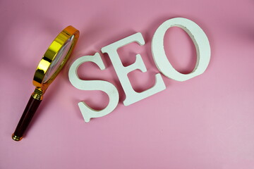 Aufkleber - Seo words (Search Engine Optimization) letters with magnifying glass on pink background