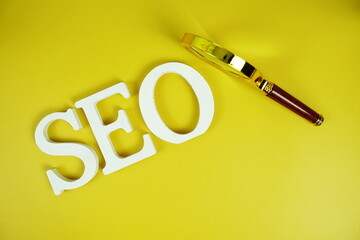 Aufkleber - SEO alphabet letter with magnifying glass on yellow background