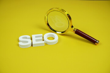 Aufkleber - SEO alphabet letter with magnifying glass on yellow background