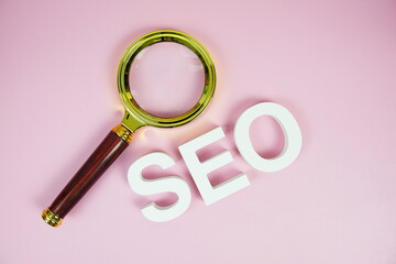 Aufkleber - Seo words (Search Engine Optimization) letters with magnifying glass on pink background