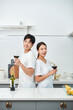 © Dialogue Frame - A young newlywed couple enjoying wine at the kitchen table on holiday, having a happy time.