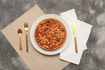 Wall Mural - plate of sweet tart with different nuts and caramel on grey background