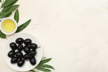 Wall Mural - Plate with tasty black olives, leaves and bowl of oil on light background