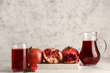 Wall Mural - glass and jug of fresh pomegranate juice on white background