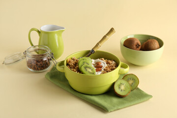 Wall Mural - bowl with tasty cornflakes, nuts and kiwi on green background