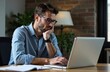 © yuntunen - thoughtful man working on laptop in a cozy office