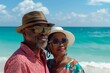 © Baba Images - Middle aged African American couple on summer vacation on a beach