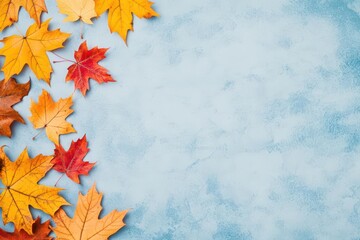 Aufkleber - A beautiful display of autumn leaves in rich colors set against a soft blue background creating a seasonal contrast