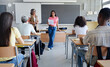 © EFStock - African American female student doing presentation reading essay to classmates and teacher at High School College classroom
