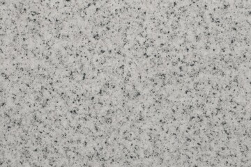 Poster - Close-up view of polished white granite, showcasing subtle textures and tiny black specks that create an elegant, natural pattern ideal for design and architecture