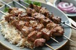 © CojanAI - Overhead view of meat kebab on a plate with rice and onion