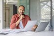 © Liubomir - Portrait of a joyful successful financier, a man behind paperwork smiling and looking at the camera, a company employee holding an investment report in his hands