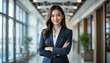 © Emon - A confident Asian businesswoman stands in a modern office corridor