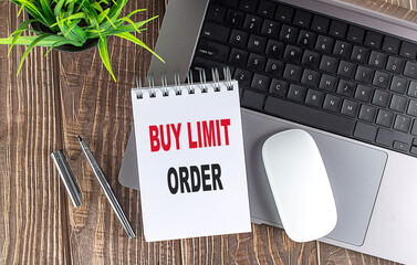 Poster - Notepad with the words buy limit order on wooden desk with laptop, mouse, pen and plant