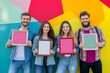 © Aleksandr - Cheerful group of young caucasian adults holding colorful frames against vibrant geometric wall