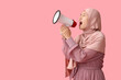 © Pixel-Shot - Young Asian Muslim woman shouting into megaphone on pink background. National Be Heard Day