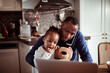 © Marko Geber - Single father multitasking talking on the phone and working on his laptop while having breakfast with his baby daughter in the kitchen