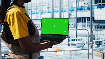 Poster - worker using green screen laptop in smart factory, collecting and analyzing data. expert using track