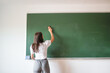 © Lupe Rodriguez/Stocksy - female student next to a blackboard in class