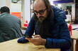 © Studio KME/Stocksy - Man Using Phone in a Local Eatery